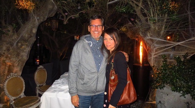 A woman and man posing for the camera and smiling.