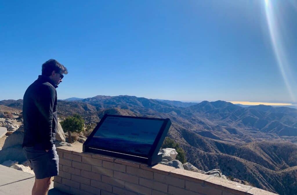 A man looking at a plaque.