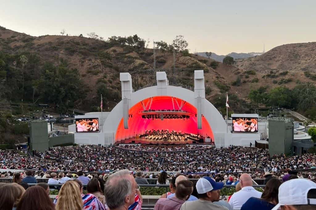 a picture of the Hollywood Bowl light in pick with thousands of people in their seats.